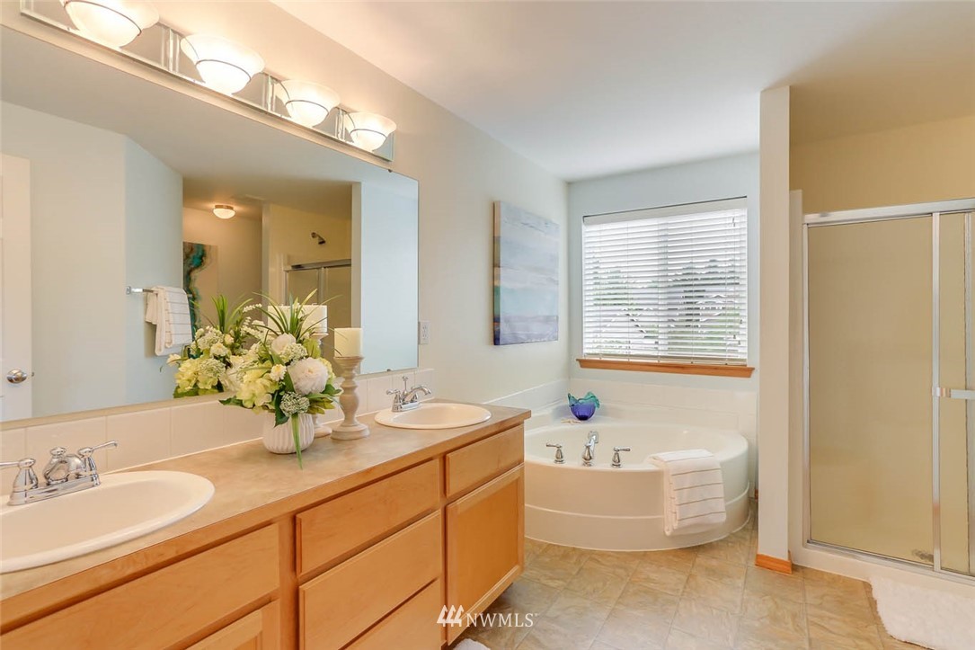 6731 Southeast 3rd Street Renton, WA 98059 - Photo 20 of 31 a bathroom with a double vanity sink bathtub and next to a window