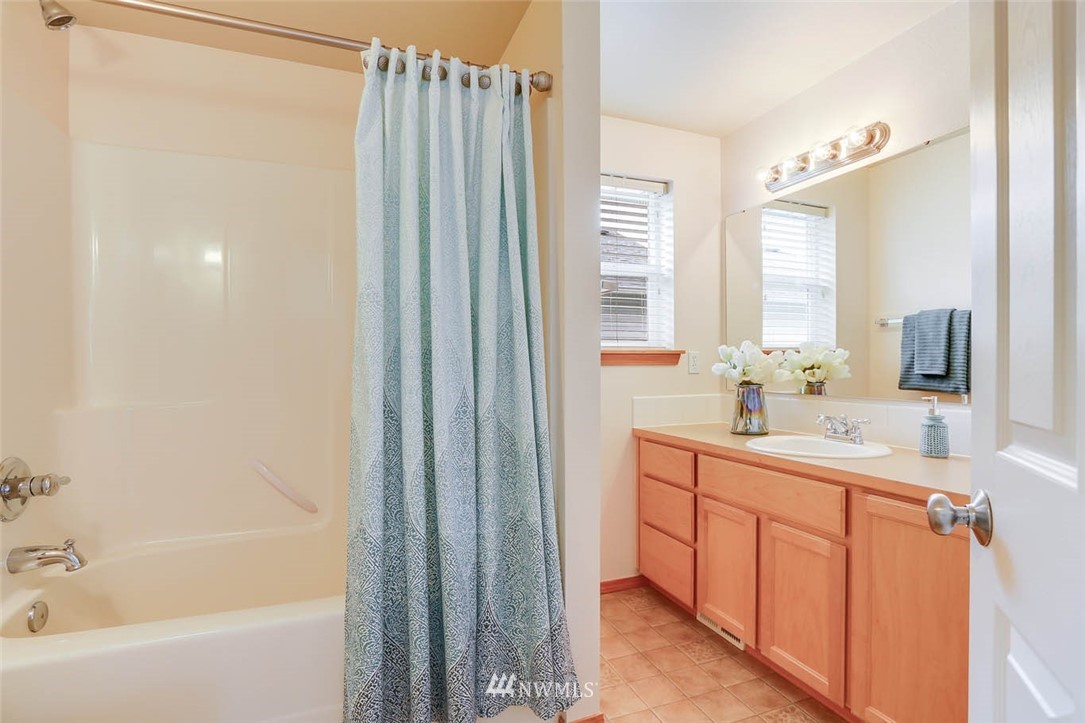 6731 Southeast 3rd Street Renton, WA 98059 - Photo 26 of 31 a bathroom with a double vanity sink a mirror a bathtub and window