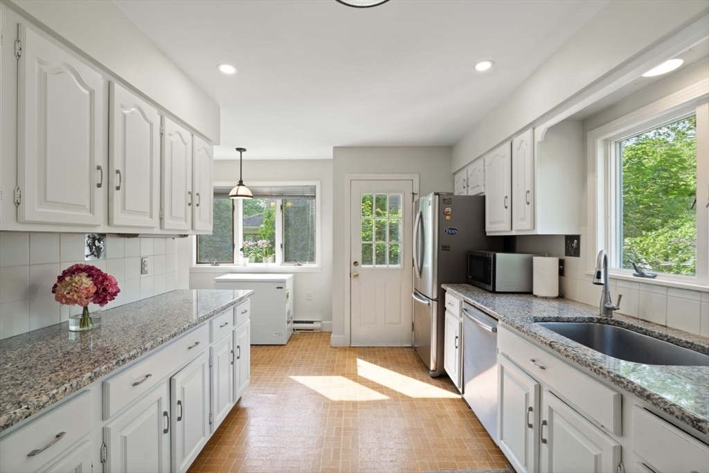 77 Meriam Street Lexington, MA 02420 - Photo 12 of 35 a large kitchen with stainless steel appliances granite countertop a lot of counter space and a sink