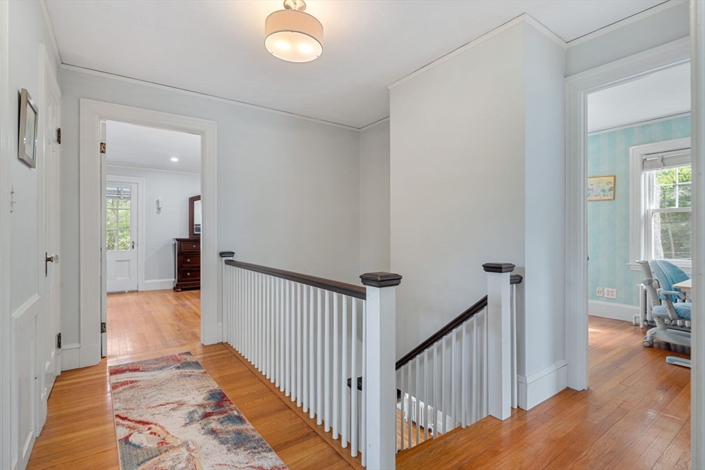 77 Meriam Street Lexington, MA 02420 - Photo 19 of 35 a view of a hallway to a livingroom with wooden floor and furniture