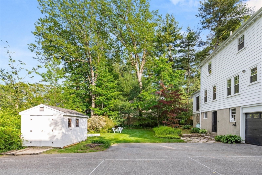 77 Meriam Street Lexington, MA 02420 - Photo 30 of 35 a front view of a house with a garden and trees