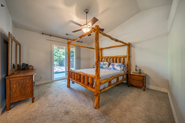 a bed sitting in a spacious bedroom next to a window
