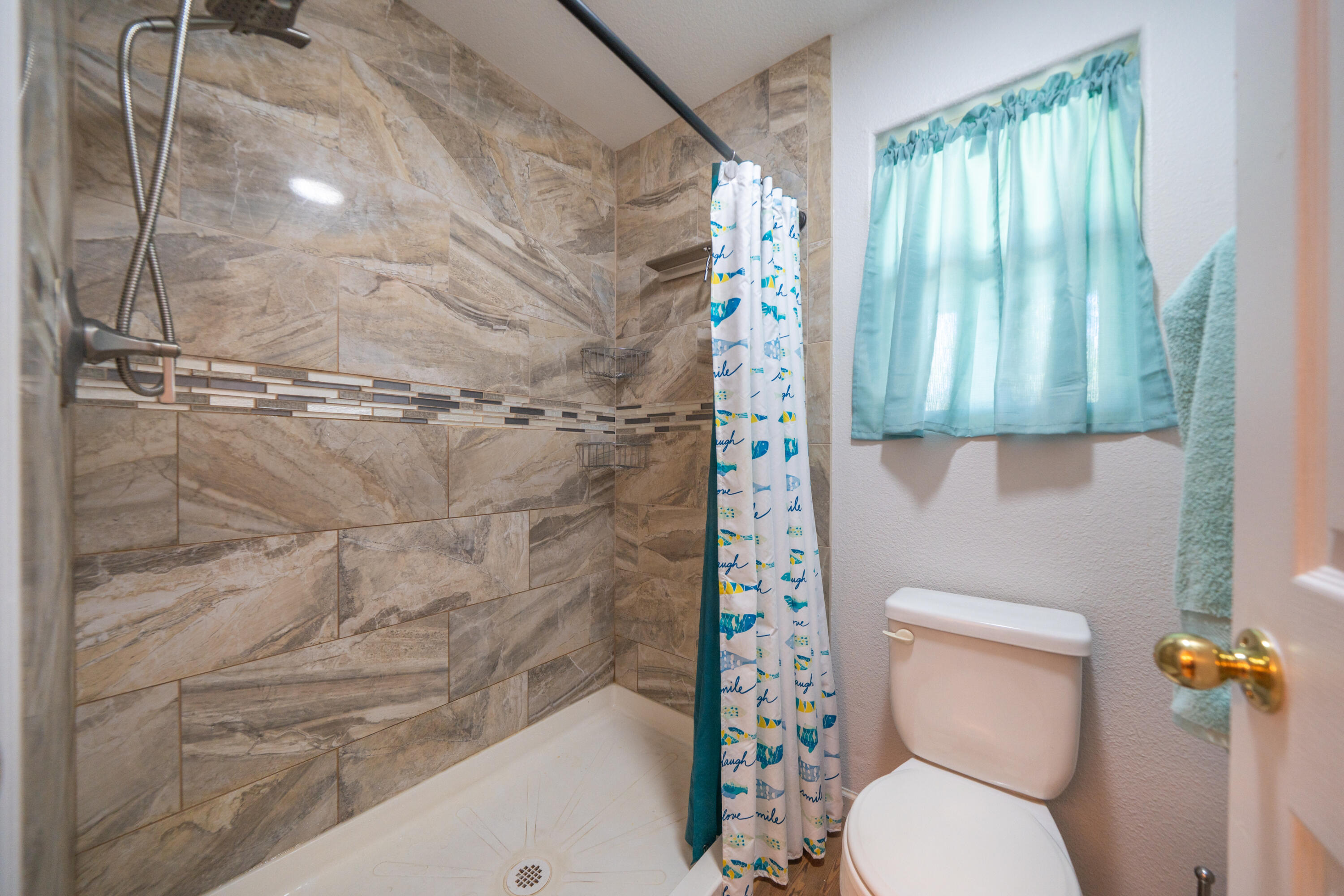 3388 Oak Street Anderson, CA 96007 - Photo 16 of 36 a white toilet sitting next to a shower curtain