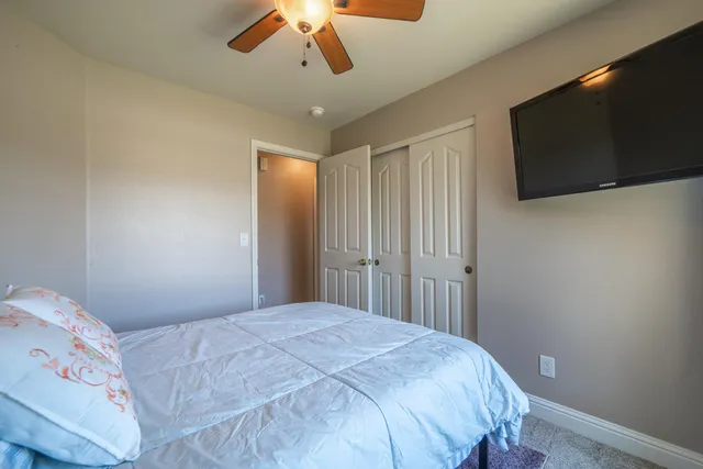 a bedroom with a bed and a ceiling fan