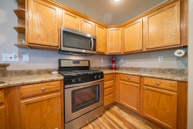 a kitchen with granite countertop a sink cabinets and stainless steel appliances