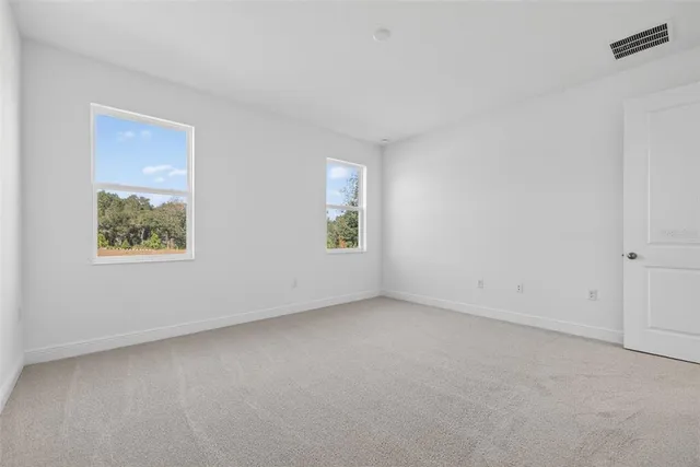 a view of an empty room with closet and entryway