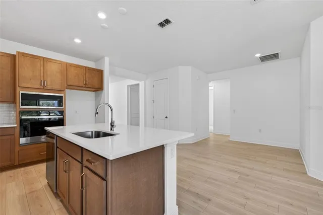 a view of a big room with wooden floor and windows