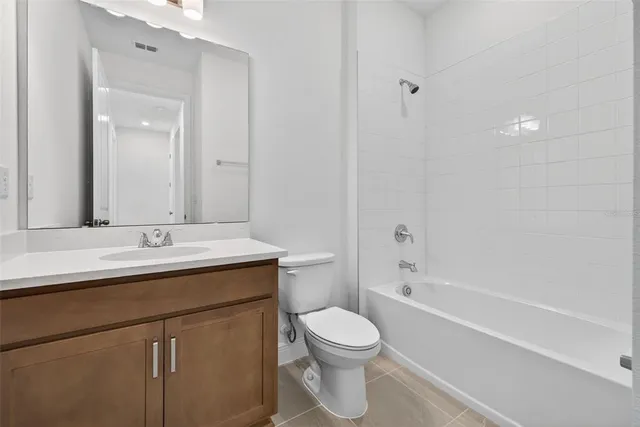 a view of an empty room with closet and a window