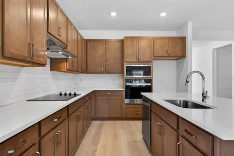 a kitchen with stainless steel appliances granite countertop a sink stove and cabinets