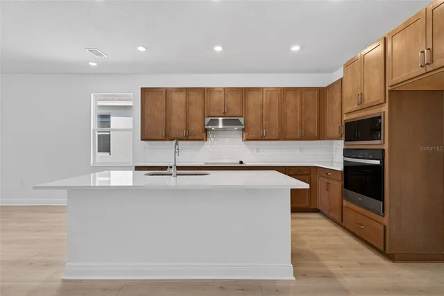 a kitchen with stainless steel appliances a sink stove and refrigerator