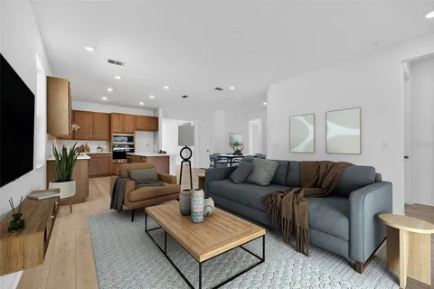 a living room with furniture kitchen view and a flat screen tv