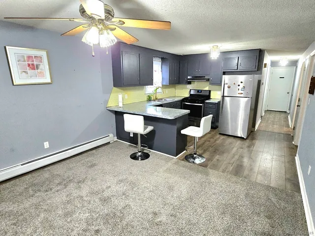 a kitchen with a refrigerator and a wooden cabinets