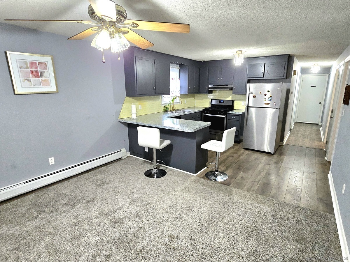 24 Acorn Street, Unit 2 New Britain, CT 06051 - Photo 3 of 12 a kitchen with a refrigerator and a wooden cabinets