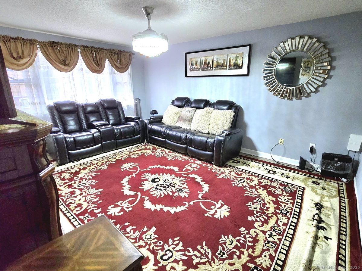 24 Acorn Street, Unit 2 New Britain, CT 06051 - Photo 5 of 12 a bedroom with a bed and a chandelier