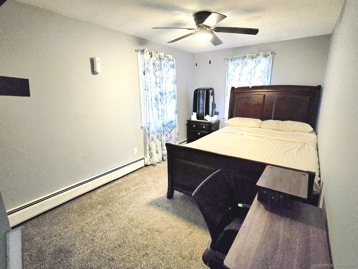 24 Acorn Street, Unit 2 New Britain, CT 06051 - Photo 8 of 12 a room with a bed and a chandelier