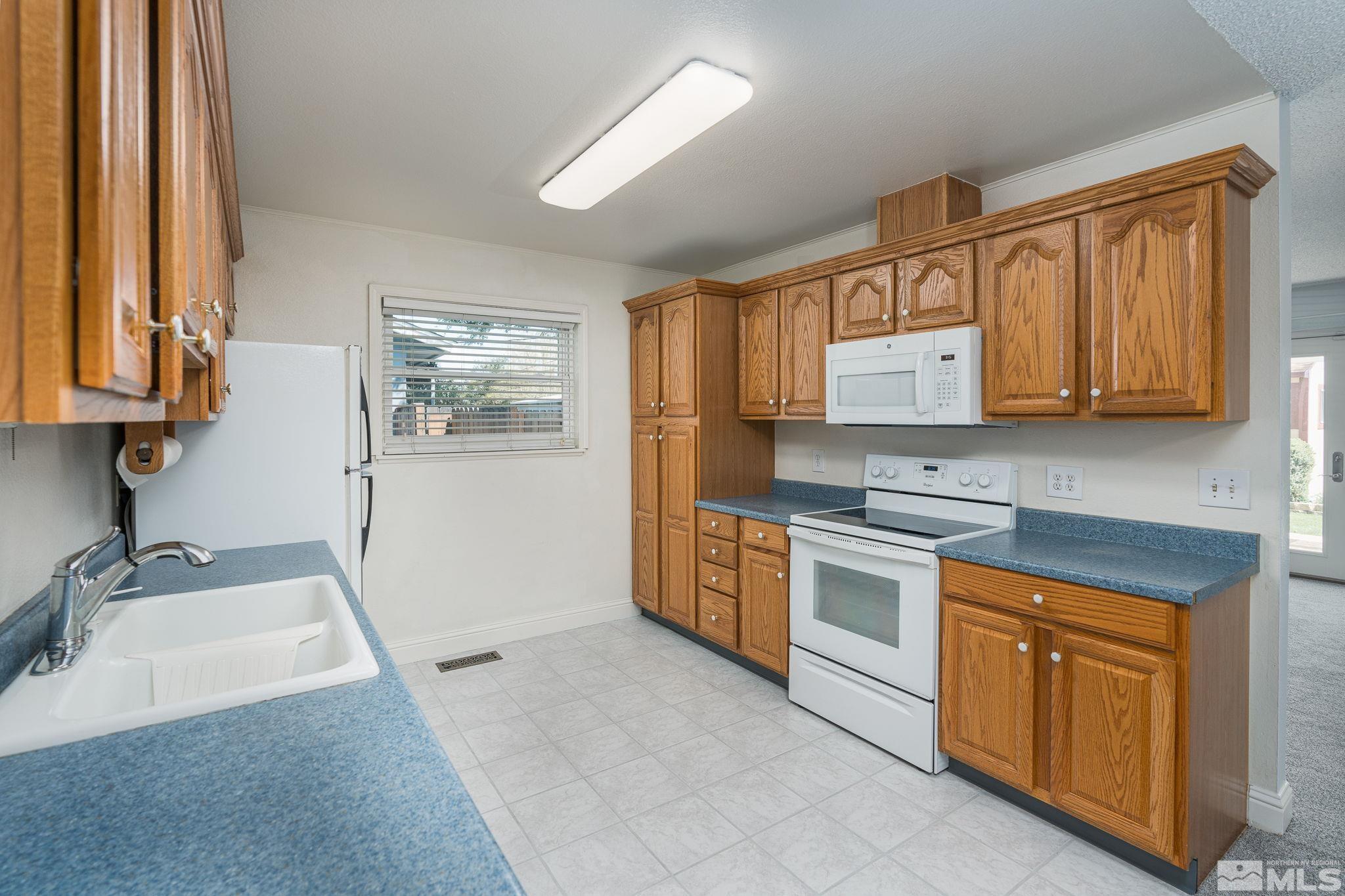 1065 Beldon Way Reno, NV 89503 - Photo 9 of 35 a kitchen with stainless steel appliances granite countertop a stove a sink and a microwave