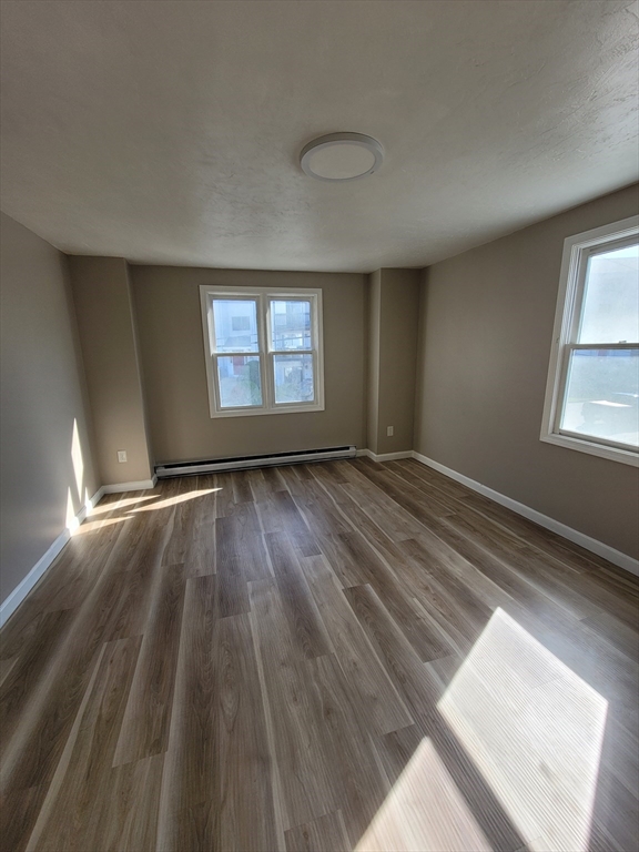 7 Gibbs Street, Unit 7 Worcester, MA 01607 - Photo 16 of 20 an empty room with wooden floor and windows