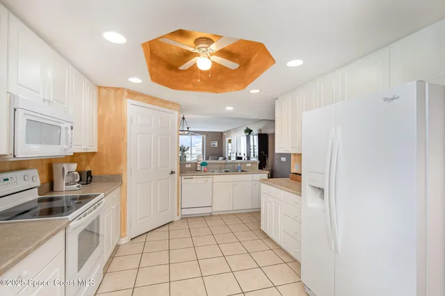 a kitchen with white cabinets and white appliances