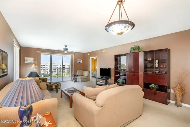 a living room with furniture a chandelier and a large window