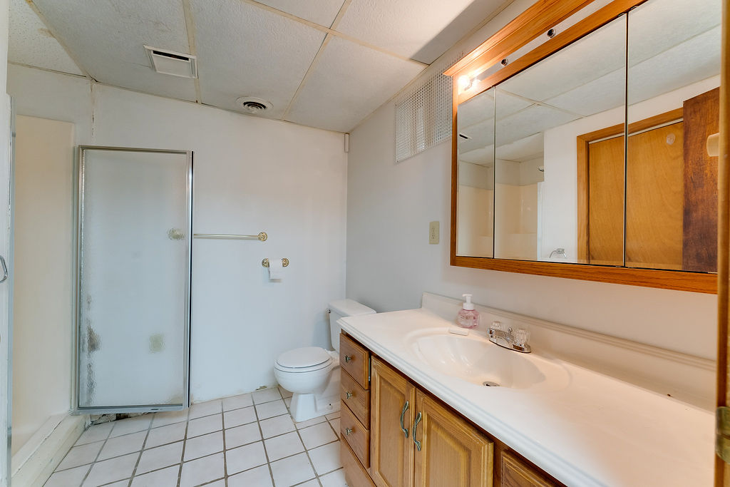 100 Nichols Ridge Road Seaman, OH 45679 - Photo 30 of 43 This clean and functional bathroom features a shower, a well-lit vanity, and tiled flooring.