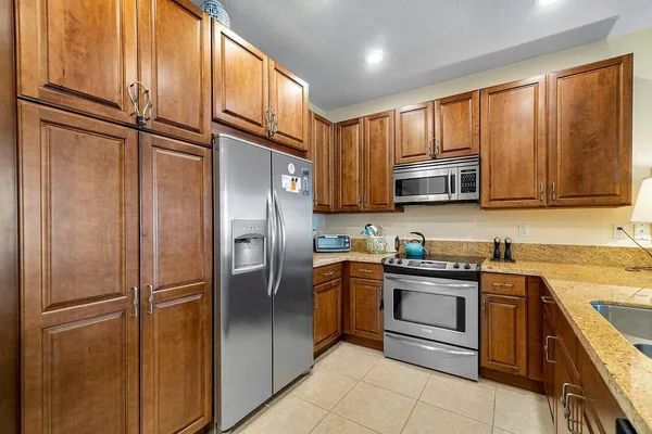 a kitchen with stainless steel appliances granite countertop a refrigerator and a sink