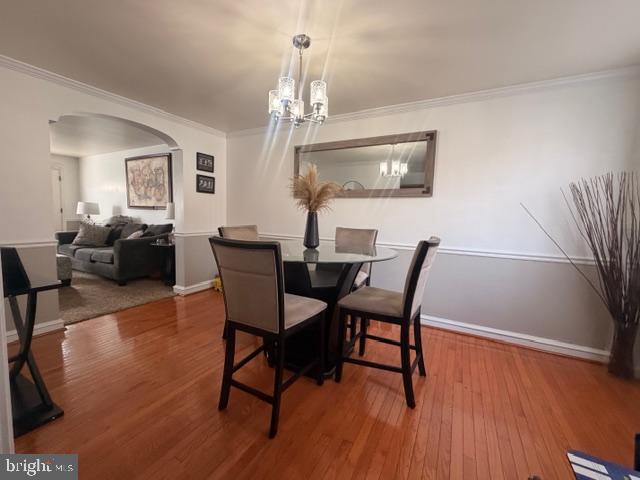 7206 Montague Street Philadelphia, PA 19135 - Photo 6 of 15 a dining room with wooden floor a chandelier a glass table and chairs