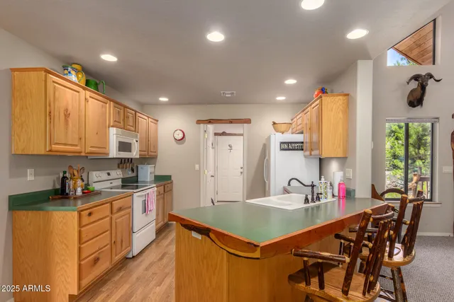 a kitchen with kitchen island granite countertop a sink cabinets and window