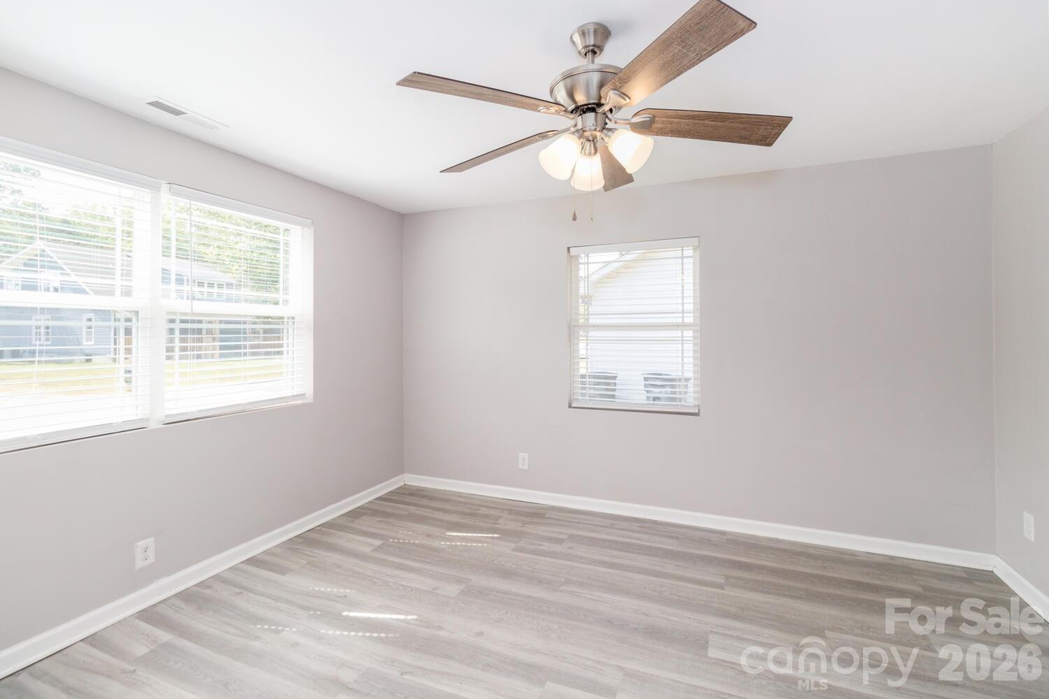 304 Bell Street Kannapolis, NC 28081 - Photo 21 of 27 an empty room with wooden floor fan and windows