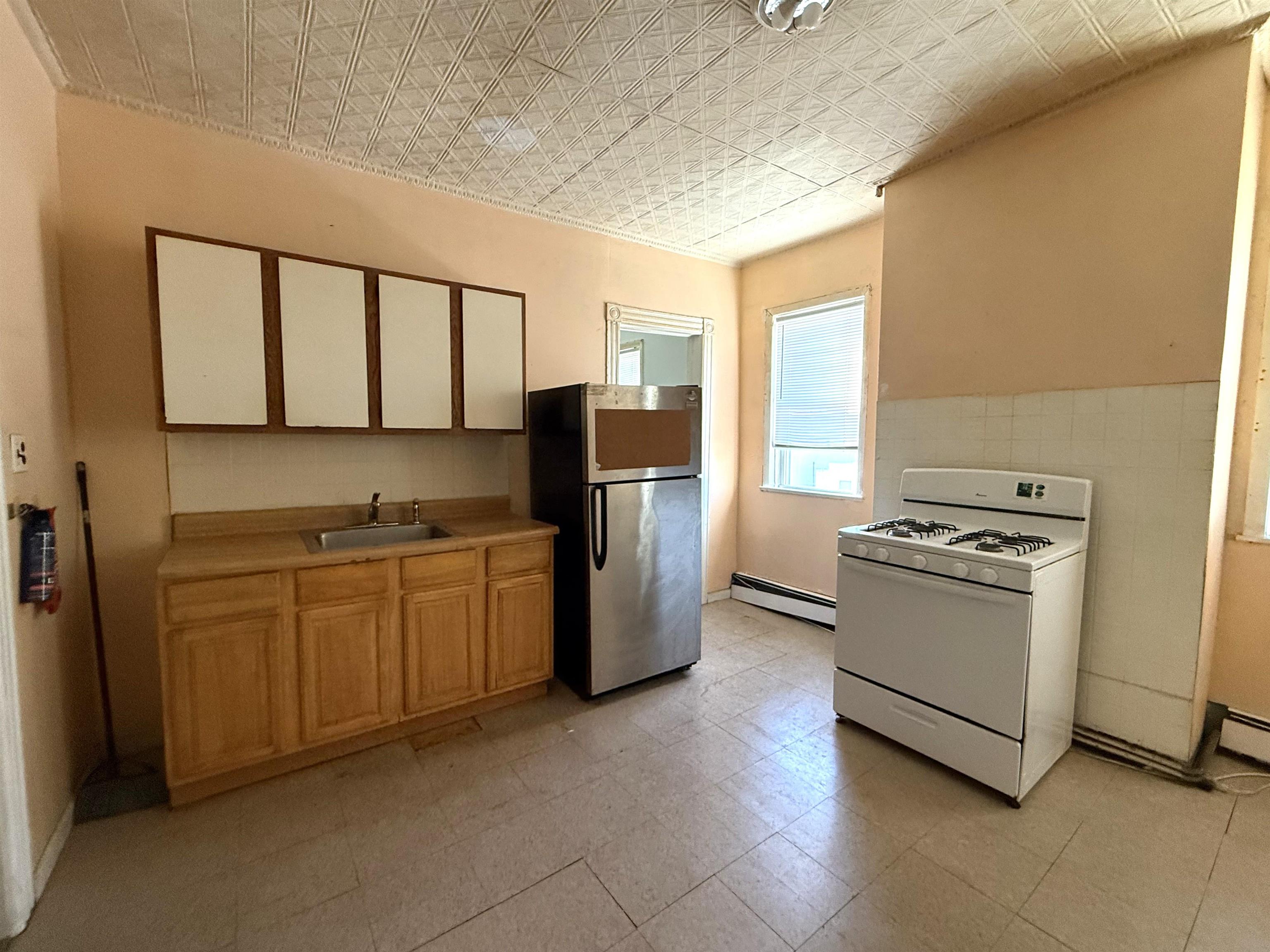 910-912 Broadway, Unit 3 Bayonne, NJ 07002 - Photo 5 of 10 a kitchen with stainless steel appliances granite countertop a stove a sink and a refrigerator