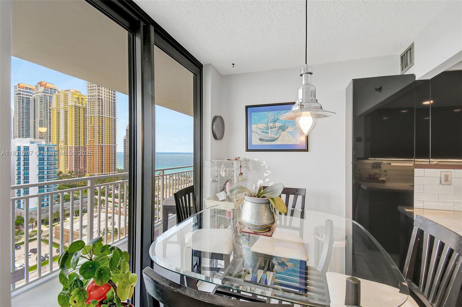 210 174th Street, Unit 2212 Sunny Isles Beach, FL 33160 - Photo 19 of 39 a view of a dining room with furniture a potted plant and wooden floor