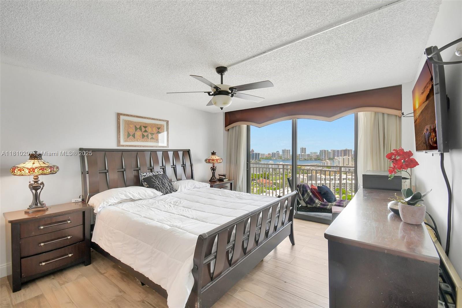 210 174th Street, Unit 2212 Sunny Isles Beach, FL 33160 - Photo 26 of 39 a bedroom with a bed and a chandelier