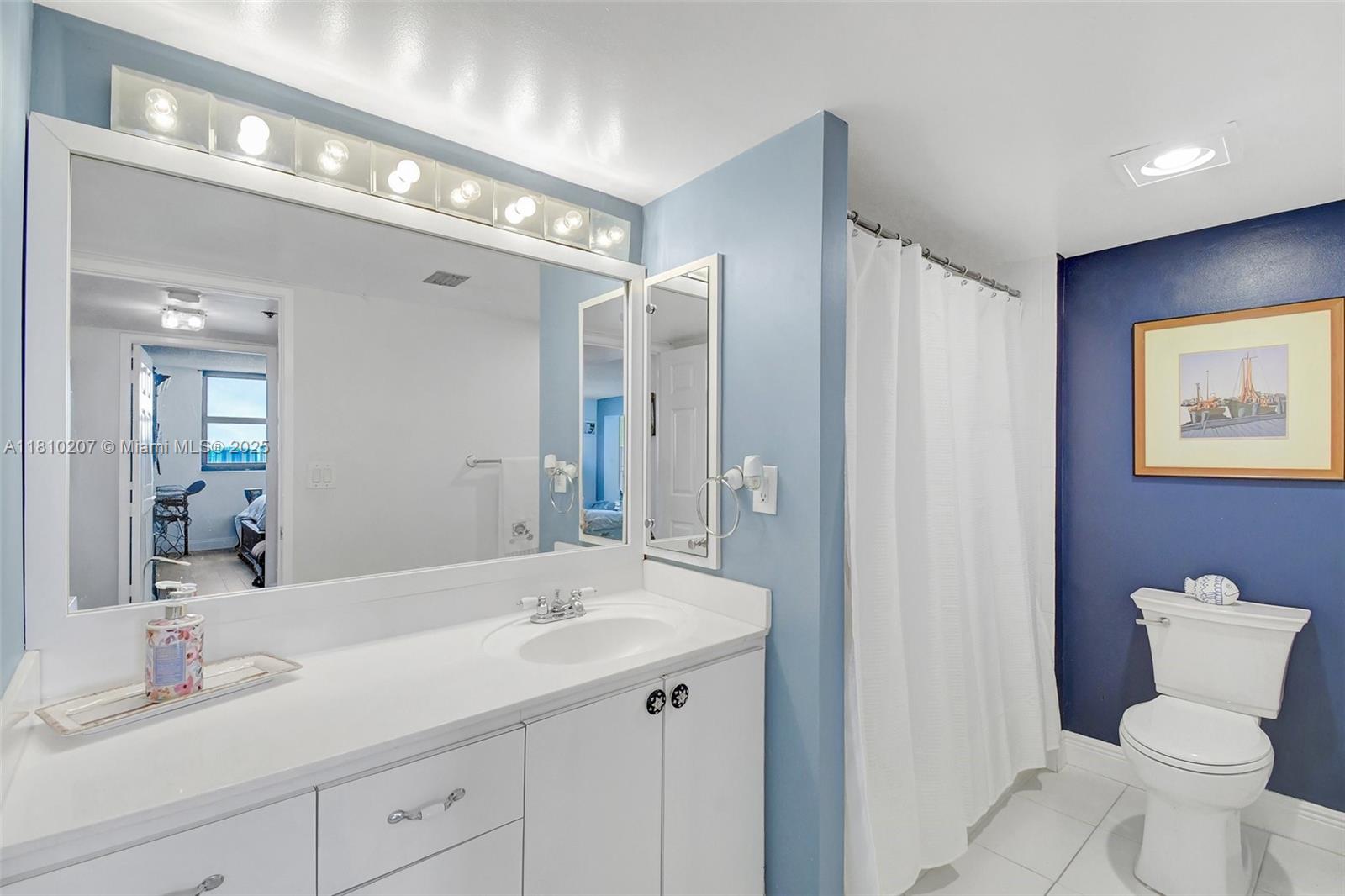 210 174th Street, Unit 2212 Sunny Isles Beach, FL 33160 - Photo 35 of 39 a bathroom with a toilet sink and mirror