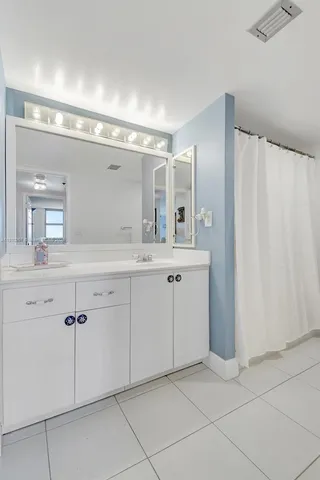a spacious bathroom with a double vanity sink and mirror