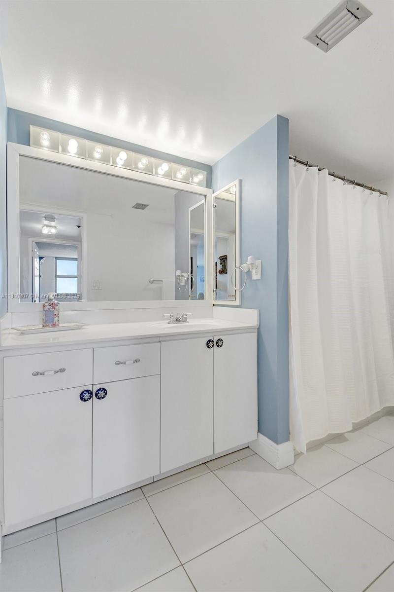 210 174th Street, Unit 2212 Sunny Isles Beach, FL 33160 - Photo 36 of 39 a spacious bathroom with a double vanity sink and mirror