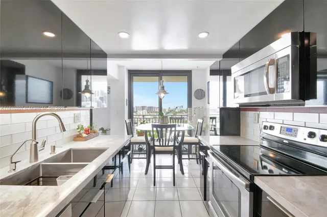 a kitchen with stainless steel appliances granite countertop a sink stove and cabinets