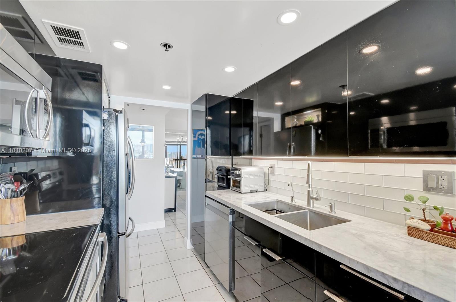 210 174th Street, Unit 2212 Sunny Isles Beach, FL 33160 - Photo 5 of 39 a bathroom with a sink a large mirror and shower