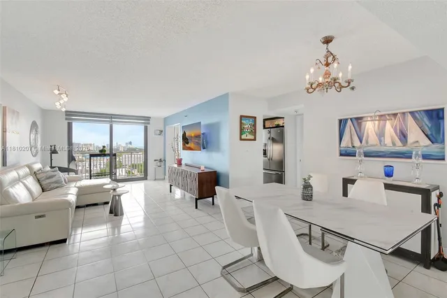 a living room with furniture a dining table and a chandelier
