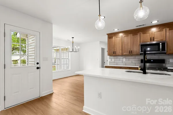 a view of kitchen with microwave and wooden floor