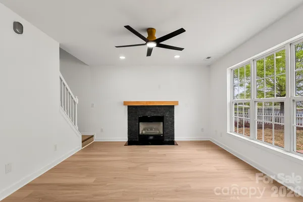 a view of an empty room with a window and fireplace