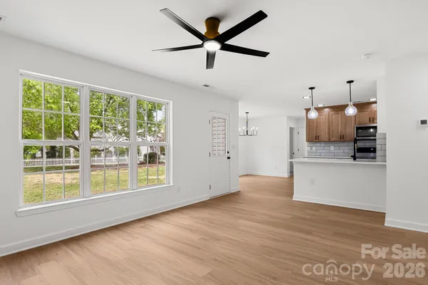 a view of an empty room with a kitchen and a stove top oven