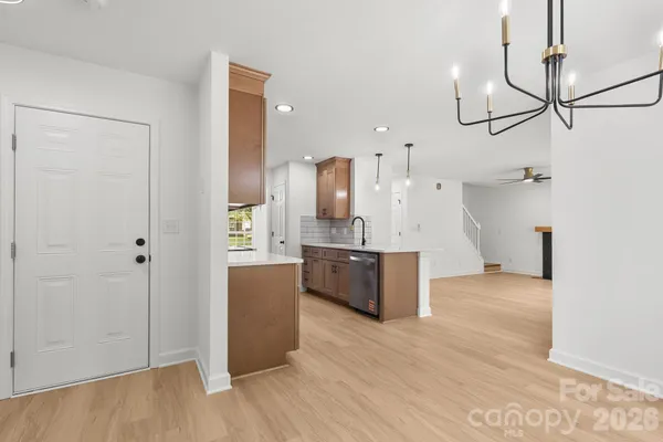 a view of a kitchen with a refrigerator and wooden floor