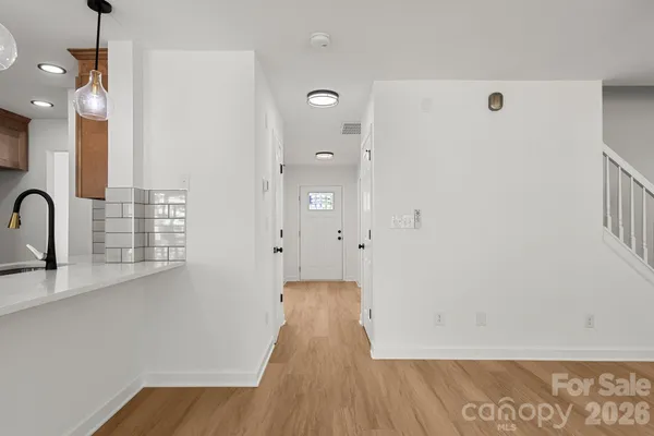 a view of a hallway with wooden floor and staircase