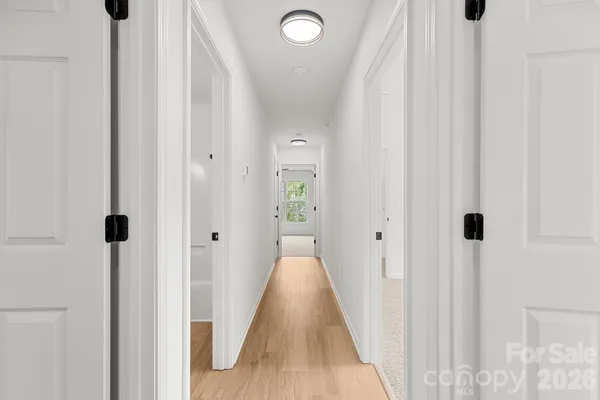a view of a hallway with wooden floor and closet