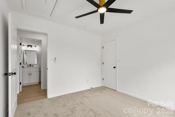 an empty room with fan and windows