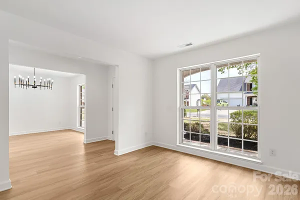 a view of a big room with wooden floor and windows