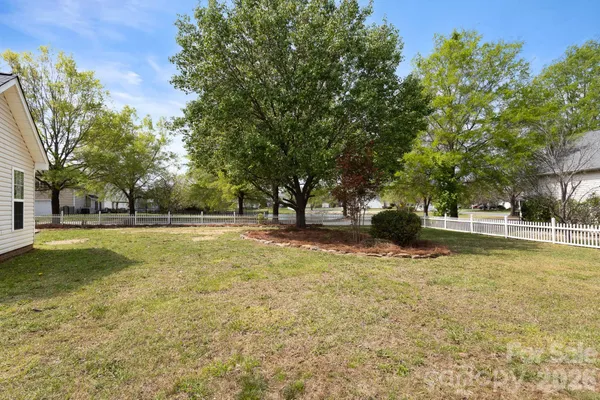 a view of a yard with wooden fence