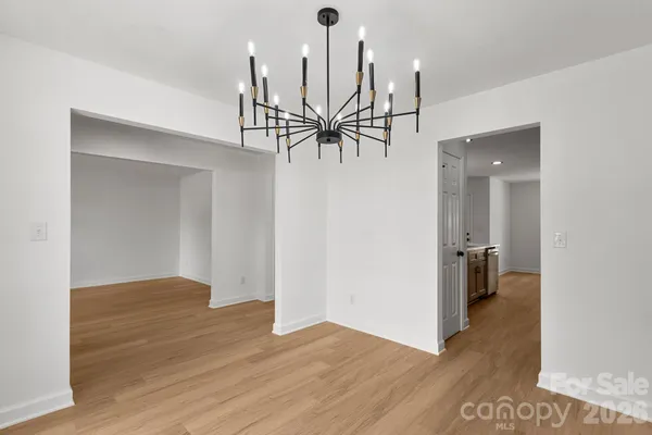 a view of empty room with wooden floor and ceiling fan