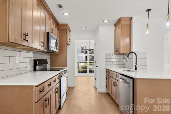 a kitchen with stainless steel appliances granite countertop a sink a stove and a refrigerator