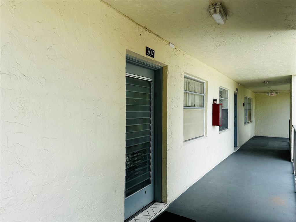 3070 Northwest 48th Terrace, Unit 307 Lauderdale Lakes, FL 33313 - Photo 12 of 13 a view of a hallway with wooden shelves