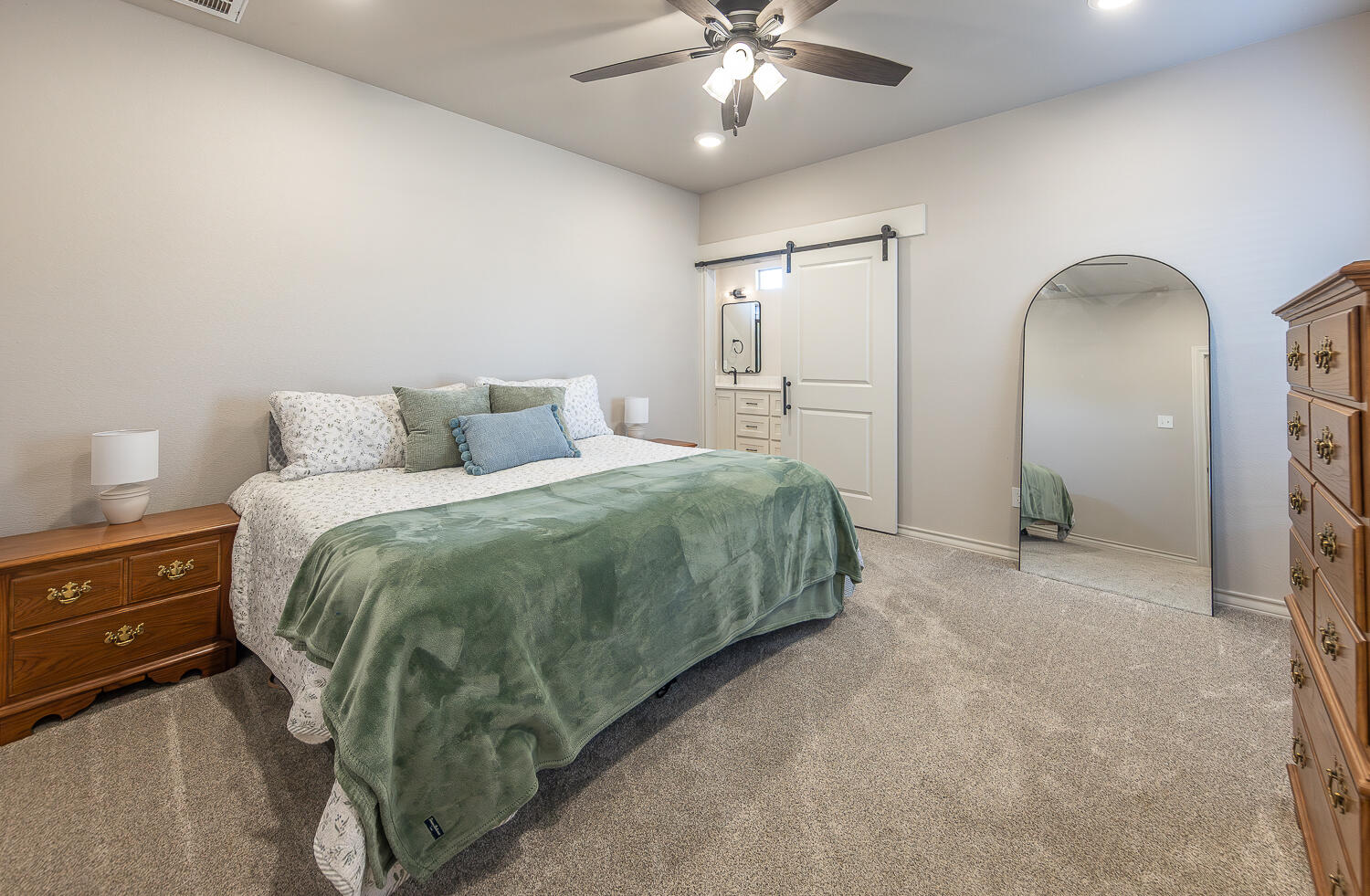 6913 15th Street Lubbock, TX 79416 - Photo 11 of 27 a spacious bedroom with a bed and a chandelier